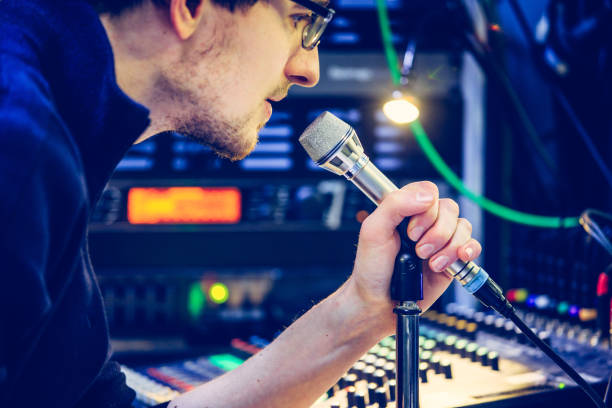 istock Studio recording: Young man speaks into a microphone, studio in the blurry background 1133566883