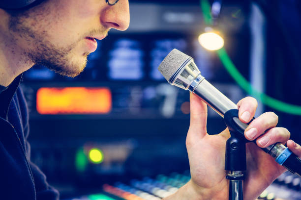 istock Studio recording: Young man speaks into a microphone, studio in the blurry background 1133566906