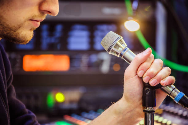 istock Studio recording: Young man speaks into a microphone, studio in the blurry background 1133566909