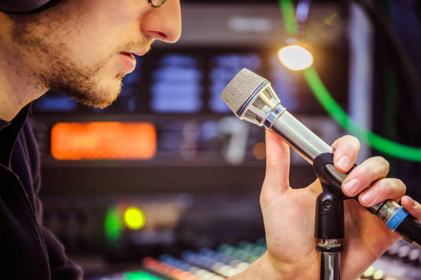 istock Studio recording: Young man speaks into a microphone, studio in the blurry background 1133566913