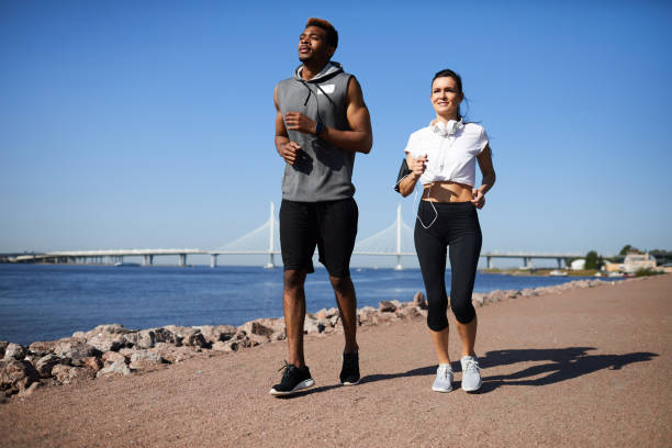 istock Multi-ethnic couple jogging on city beach 1133568244