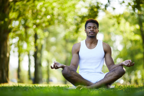 istock Relaxed black man meditating alone in park 1133568294