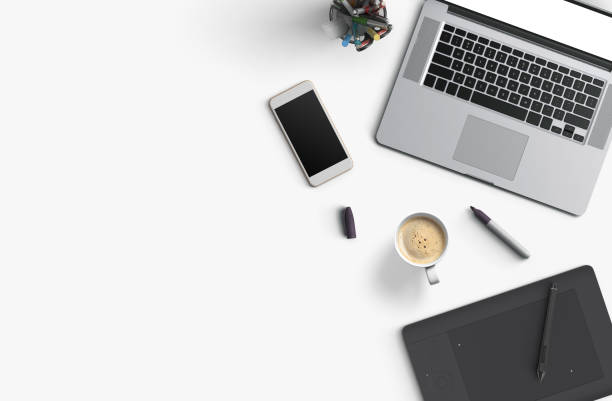 Office desk table with laptop computer, smartphone with black screen over a notebook and cup of coffee. Top view with copy space, flat lay.