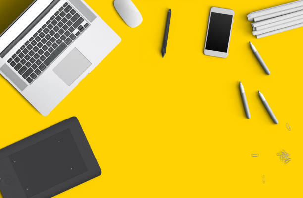 istock Minimal work space concept: smart phone, pen, pencils, tablet, laptop, composition on yellow background. Flat lay, top view. Copy space 1133570485
