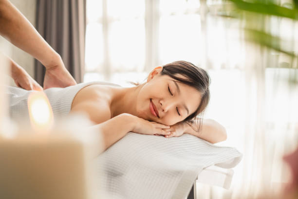 jeune femme asiatique de beauté appréciant le massage et le spa - asian ethnicity asia massaging spa treatment photos et images de collection
