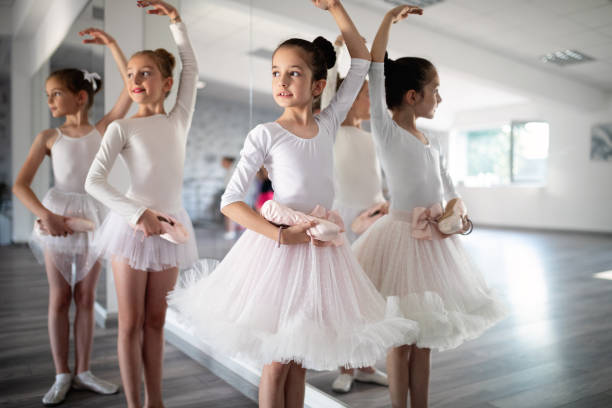 grupo de niños felices aptos ejercitando ballet en estudio juntos - ballet dress studio shot costume fotografías e imágenes de stock