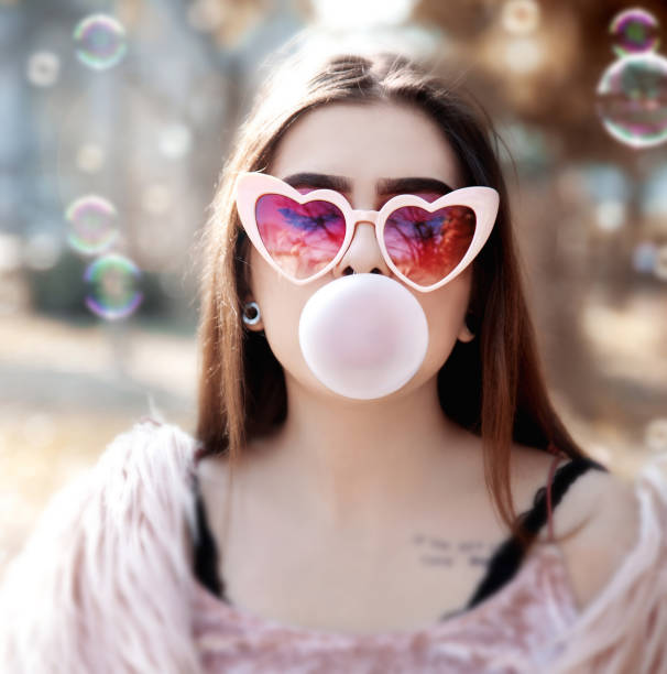 istock Young woman blowing bubble gum 1133576222