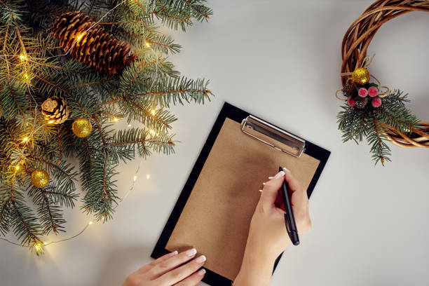 istock Flat lay of juniper wreath green pine tree branches, wreath and craft paper on white table, top view. 1133576927