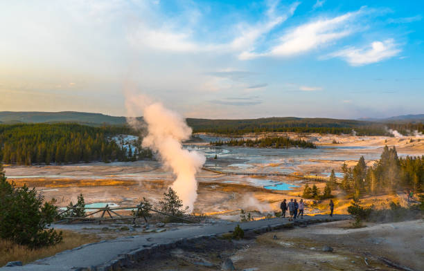 Yellowstone National Park, WY, USA Yellowstone National Park, WY / USA - August 26th, 2017: Sunset at Norris Pocelain Basin / Tourists walking by the wooden runway / Steam vents norris geyser basin photos stock pictures, royalty-free photos & images