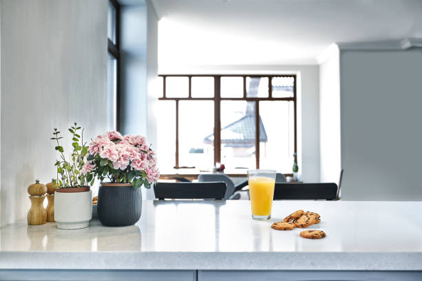 istock Appetizing sweet orange juice and one drinking glasses standing on a white table in the kitchen for a breakfast. 1133581735