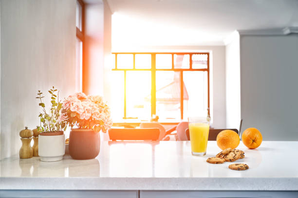 istock Appetizing sweet orange juice and one drinking glasses standing on a white table in the kitchen for a breakfast. 1133581749