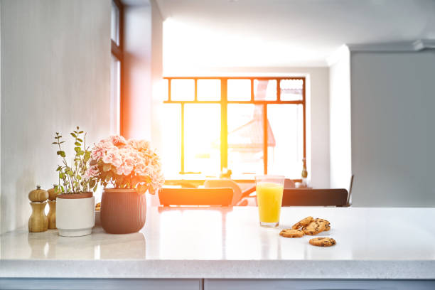 istock Appetizing sweet orange juice and one drinking glasses standing on a white table in the kitchen for a breakfast. 1133581756