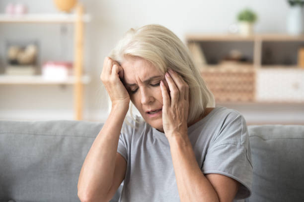 istock Close up aged woman suffering from headache, touching head 1133581865