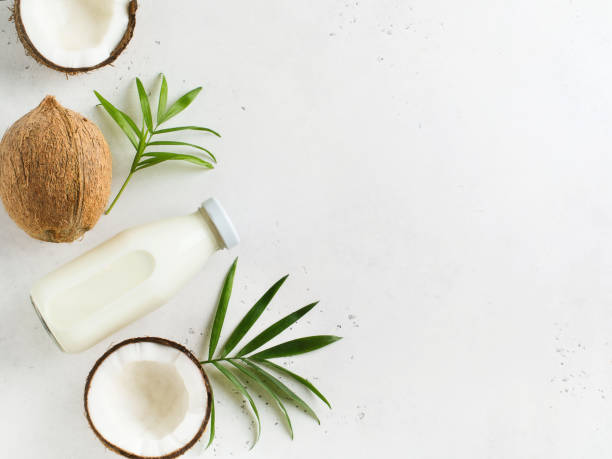 istock Coconut milk in glass bottle with coconuts on white 1133583317