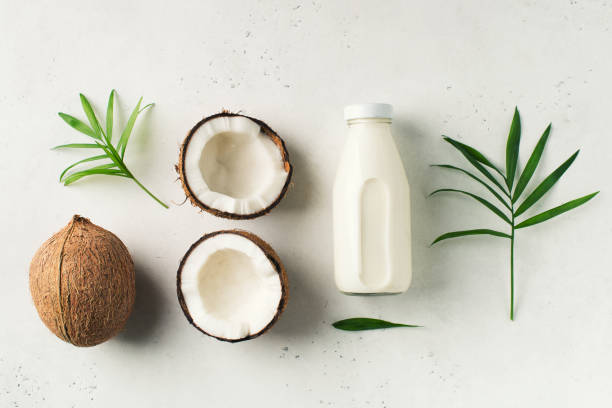 istock Coconut milk in glass bottle with coconuts on white 1133583329