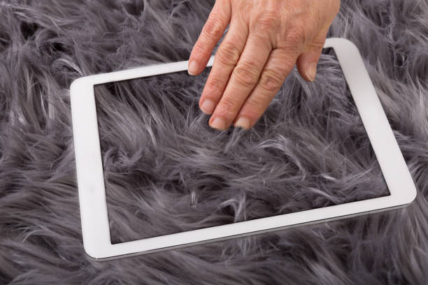 Human hand reaches into fur in computer Fur like real to touch on the Tablet PC berühren stock pictures, royalty-free photos & images