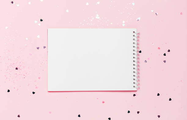 istock Empty note book on Pink confetti and stars and sparkles background. 1133584373
