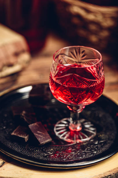 Glass of red liquor with chocolate bars Glass of red liquor with chocolate bars on metal tray nalewka stock pictures, royalty-free photos & images
