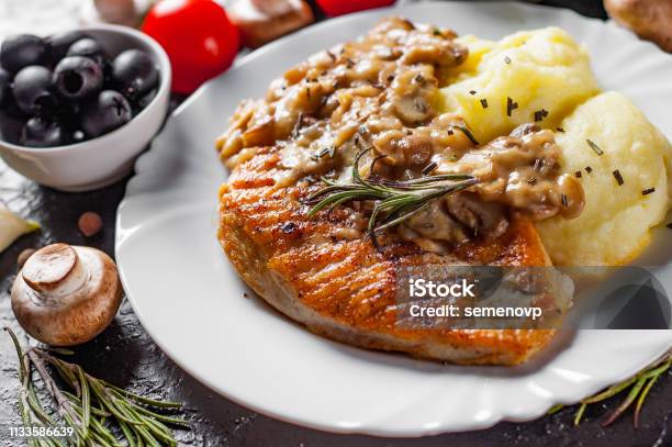 Roasted Chicken Breast With Mushroom Sauce And Mashed Potato In White Plate On Dark Background Stock Photo - Download Image Now