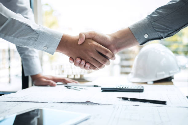 istock Handshake of collaboration, Construction engineering or architect discuss a blueprint and building model while checking information on sketching, meeting for architectural project of partner 1133587442