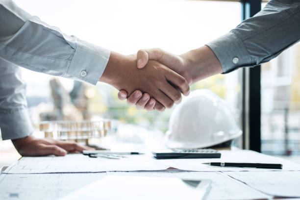 istock Handshake of collaboration, Construction engineering or architect discuss a blueprint and building model while checking information on sketching, meeting for architectural project of partner 1133587452
