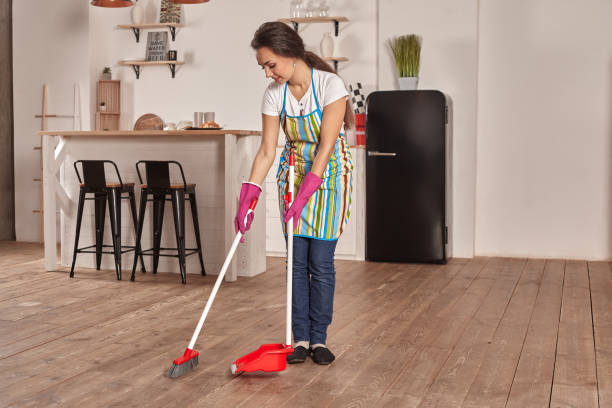 istock Young woman sweeping floor on the kitchen 1133588345