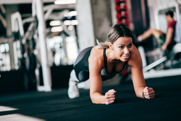 istock Sporty woman doing plank exercise on the gym floor. 1133588423