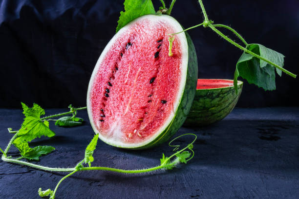 Fresh Water melon fruit cut in half on a black background. Fresh Water melon fruit cut in half on a black background. healthy eating red above studio shot stock pictures, royalty-free photos & images
