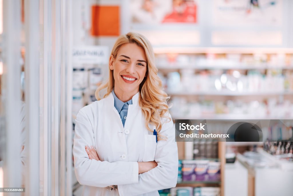 Portrait of a smiling healthcare worker in modern pharmacy. Pharmacy Stock Photo