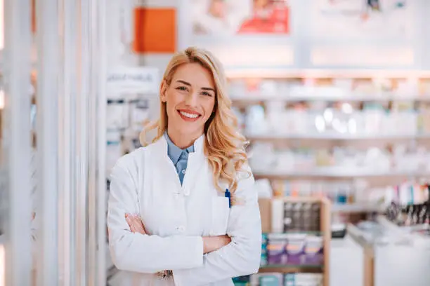 Portrait of a smiling healthcare worker in modern pharmacy.