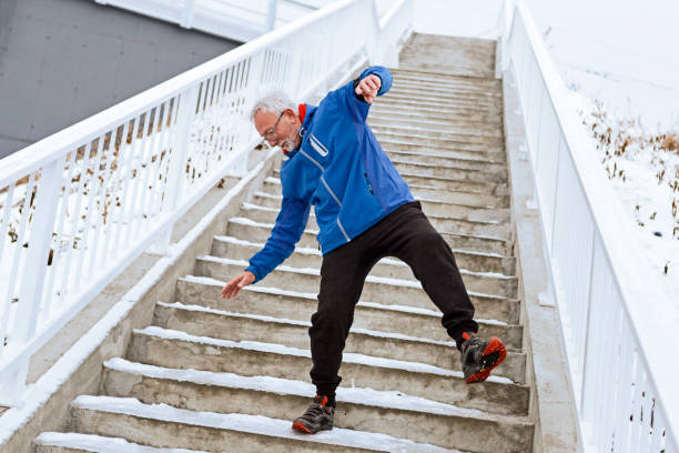 senioren-mann auf eisiger treppe gefallen - falling senior adult people one person stock-fotos und bilder