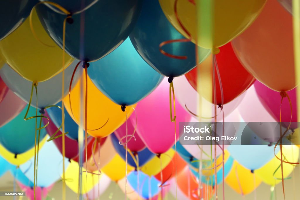 Helium balloons with ribbons in the office Colorful festive background for birthday celebration, corporate party Birthday Stock Photo