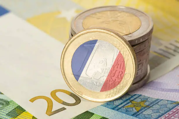 Euro banknotes and coins and flag of France
