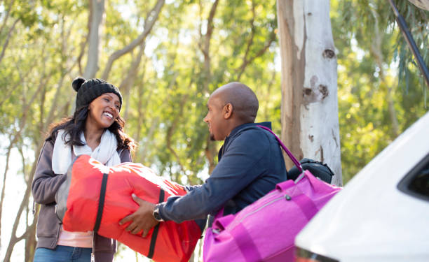 istock Couple loading together luggage into car trunk. 1133590269