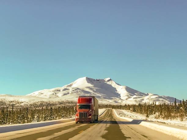 Alaska Transportation Picture of a semi-truck as it makes its way up the Glenn Highway, in Alaska.  The stunning landscape of the Alaskan winter makes for an amazing display of nature’s beauty.  Picture was taken near Gunsight Mountain in the winter. prince william sound photos stock pictures, royalty-free photos & images
