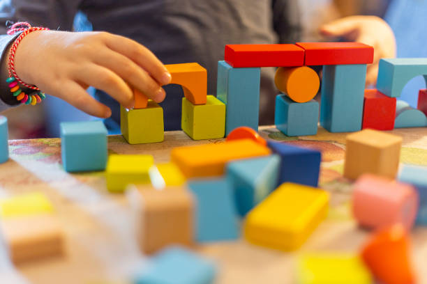 istock a child plays with colored wooden blocks at home. 1133591932