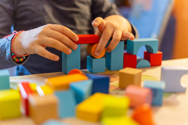 istock a child plays with colored wooden blocks at home. 1133591951