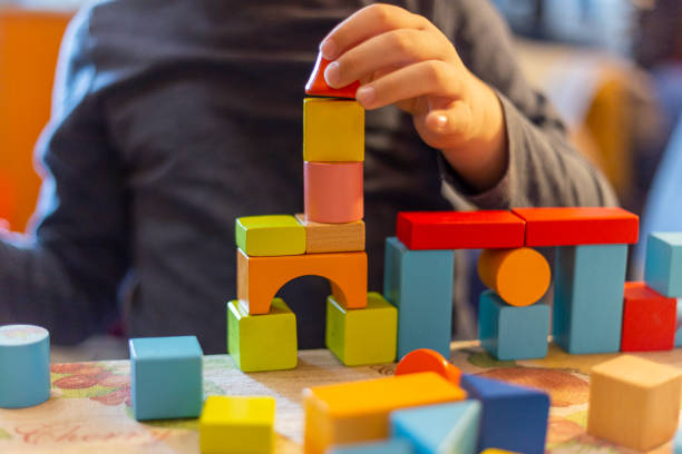 istock a child plays with colored wooden blocks at home. 1133591999