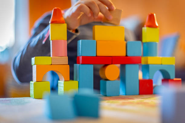 istock a child plays with colored wooden blocks at home. 1133592052