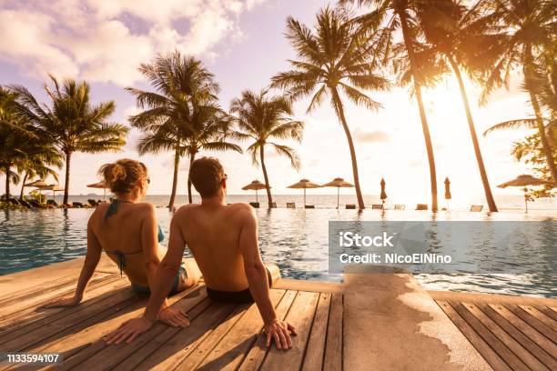 Ein Paar Genießen Sie Strandurlaub In Einem Tropischen Resort Mit Pool Und Kokospalmen In Der Nähe Der Küste Mit Schöner Landschaft Bei Sonnenuntergang Flitterwochenziel Stockfoto und mehr Bilder von Urlaub