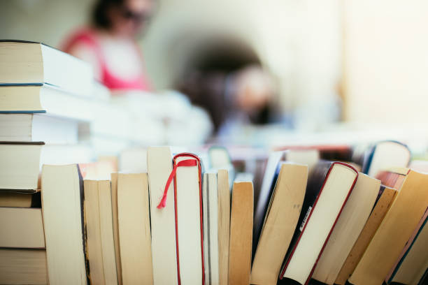 Stack of books at a charity book flea market, text space Stack of books, blurry background: Charity book flea market, outdoors. Text space. benefits of reading book stock pictures, royalty-free photos & images