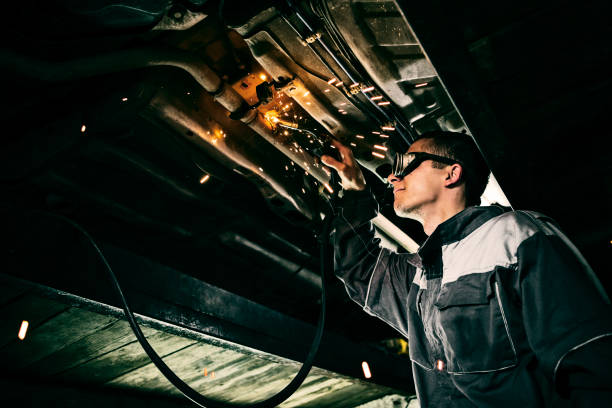 istock Mechanic working hard welding car bottom with protective goggles 1133594415