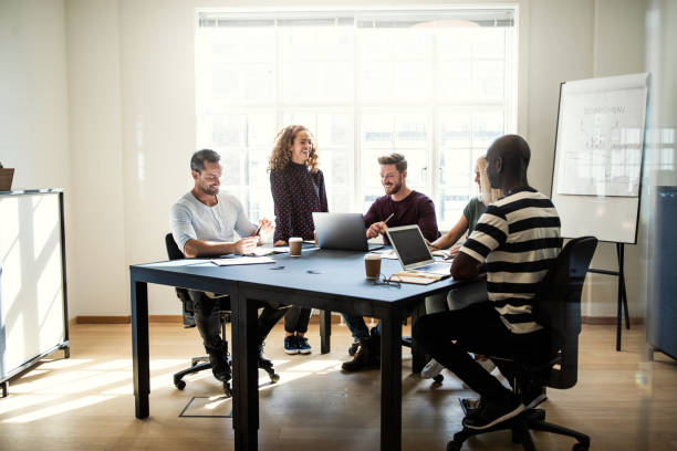 istock Smiling group of designers working together around an office table 1133598827
