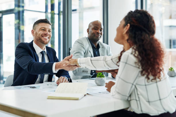 Allow me to be the first to welcome you to the team Shot of businesspeople shaking hands in an office job search stock pictures, royalty-free photos & images