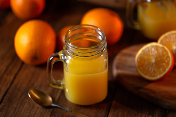 istock Orange juice glass jar shot on rustic wooden table 1133599405