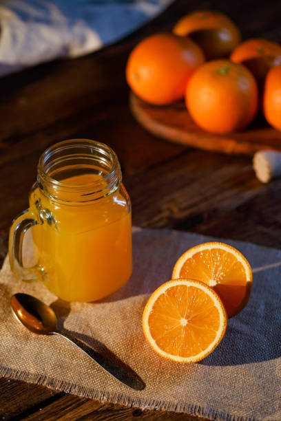 istock Orange juice glass jar shot on rustic wooden table 1133599406