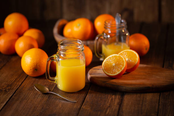 istock Orange juice glass jar shot on rustic wooden table 1133599486