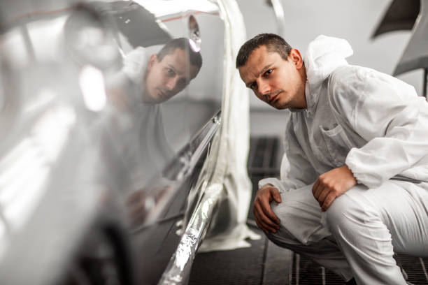 istock Car painting technician checking out paint consistency on a freshly painted door segment 1133601224