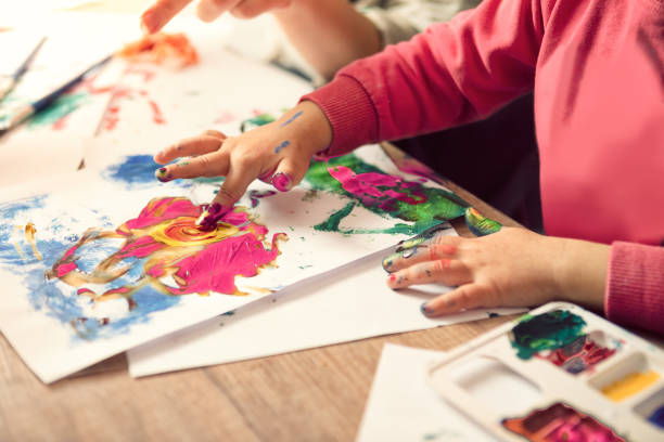 Little girl painting with finger Hands of painting little girl and the table for creativity historical geopolitical location photos stock pictures, royalty-free photos & images