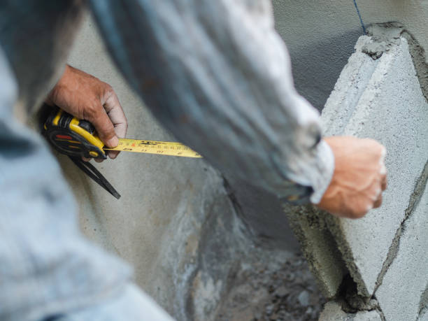 istock professional construction worker uses measuring Tape for measure and laying bricks with cement. 1133609037